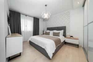 a bedroom with a large bed and a chandelier at Guesthouse Čivljak in Baška Voda