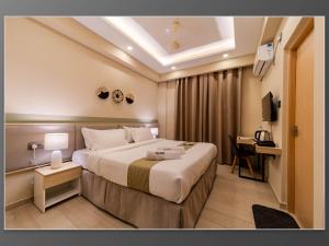 a hotel room with a large bed and a desk at Aywa Hotels Edapally in Cochin +53 photos