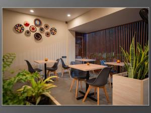 a restaurant with tables and chairs and plants at Aywa Hotels Edapally in Cochin