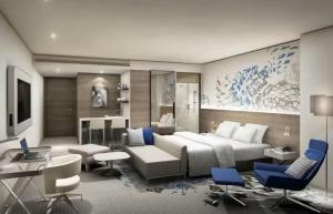 a living room with a large bed and blue chairs at Hotel Daira Suite Near IGI Airport Delhi in New Delhi