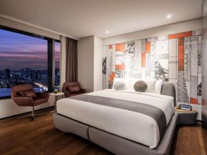 a bedroom with a large bed and a large window at Hotel Daira Suite Near IGI Airport Delhi in New Delhi
