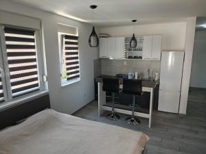 a kitchen with a refrigerator and a table and chairs at DANICA in Sremska Mitrovica