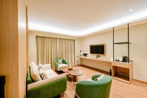 a living room with a couch and chairs and a television at ACASA Collective in Aurangabad