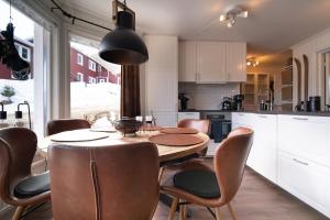 a kitchen with a wooden table and chairs and a dining room at Central Ski-In Ski-Out Apartment in Vemdalen +12 photos