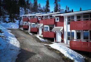 a row of red and white buildings in the snow at Central Ski-In Ski-Out Apartment in Vemdalen