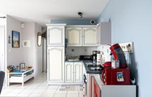 a kitchen with white cabinets and a red refrigerator at La Rose des Mers in Tréffiagat