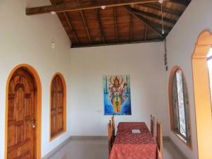 a dining room with a table and a painting on the wall at Laxmi Villa in Kalkudah