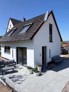 a white house with a roof and a patio at Modernes Tinyhouse im Weserbergland nahe Hameln in Hessisch Oldendorf