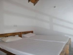 a large white bed with two pillows on it at Laxmi Villa in Kalkudah