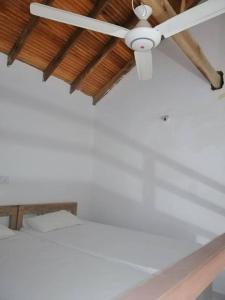 a ceiling fan sitting on top of a bed at Laxmi Villa in Kalkudah