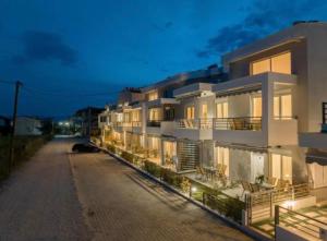 a large white building with chairs in front of it at Nefeli's 13,6 Apartment in Orfánion
