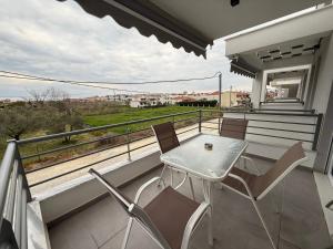 a table and chairs on a balcony with a view at Nefeli's 13,6 Apartment in Orfánion