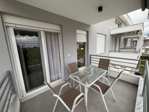 a patio with a table and chairs on a balcony at Nefeli's 13,6 Apartment in Orfánion