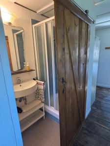 a bathroom with a wooden door and a sink at Villa Doubledot in Piane di Montorio