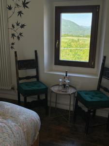 a bedroom with two chairs and a table and a window at Villa Doubledot in Piane di Montorio