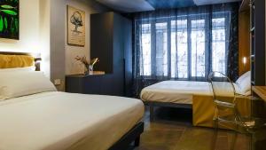 a hotel room with two beds and a window at Suiteincenter Rooms in Palermo