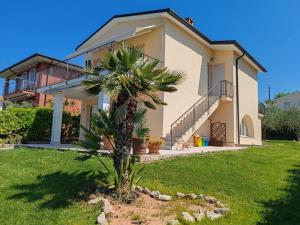 a house with a palm tree in front of it at La casa di Viola in Bardolino