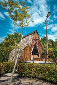 a small bamboo house with a grass roof at Hotel MulataRetreat in La Mesa
