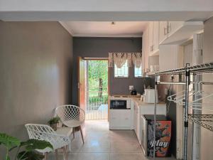 a kitchen with white appliances and chairs in a room at Grey Crescent living in Welkom