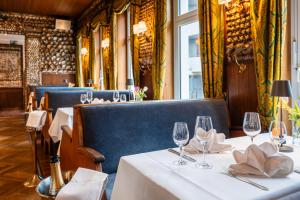 a row of tables in a restaurant with wine glasses at Hotel Alter Muschelsaal in Büsum