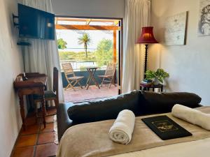 a living room with a leather couch and a patio at Goblin's Inn in St. Helena Bay