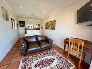a bedroom with a couch and a bed and a desk at Goblin's Inn in St. Helena Bay