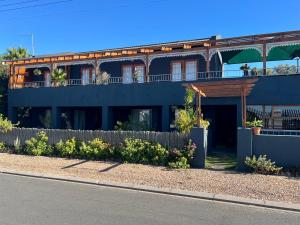a blue house with a fence in front of it at Goblin's Inn in St. Helena Bay