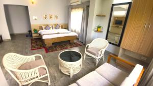 a room with a bed and chairs and a couch at Happy Villa Guest House in Guwahati