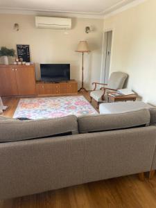 a living room with a couch and a chair at 3 bedroom Creswell Street Cottage - Pet Friendly in West Wyalong