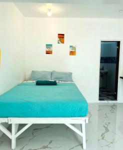 a bed in a white room with a blue mattress at Spacious studio 4, AC, kitchenette, central location in Coron