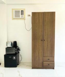 a wooden door in the corner of a room with a microwave at Spacious studio 4, AC, kitchenette, central location in Coron