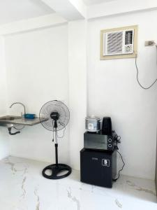 a corner of a room with a fan and a microwave at Spacious studio 4, AC, kitchenette, central location in Coron