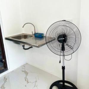 a fan in a kitchen next to a sink at Spacious studio 4, AC, kitchenette, central location in Coron +15 photos