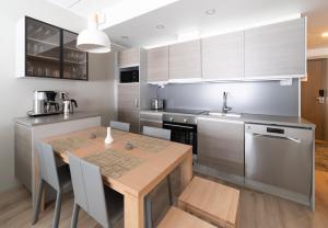 a kitchen with a wooden table and a kitchen with stainless steel appliances at Ride & Glide Ylläs, lakanat ja loppusiivous sisältyvät in Ylläsjärvi
