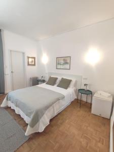 a white bedroom with a large bed and two tables at Porta 80 House in Braga