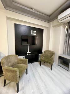 a living room with two chairs and a television at Retro Boutique in Istanbul