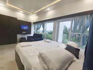a bedroom with a large bed and a large window at Yercaud Rathna Residency in Yercaud +49 photos