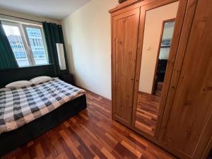 a bedroom with a bed and a large wooden cabinet at Elegancki apartament w centrum in Warsaw