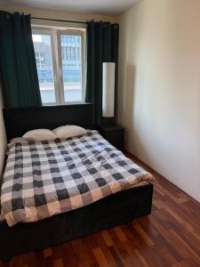 a bedroom with a checkered bed with a window at Elegancki apartament w centrum in Warsaw