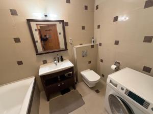 a bathroom with a toilet sink and a washing machine at Elegancki apartament w centrum in Warsaw