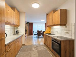 a kitchen with wooden cabinets and a dining room at Seehaus Gori in Maria Wörth