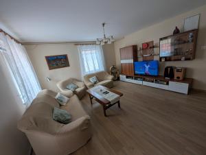 a living room with two couches and a tv at Balaton House in Balatonboglár
