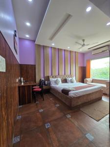 a bedroom with a large bed and purple walls at Hotel Mannat Shalimar in New Delhi +13 photos