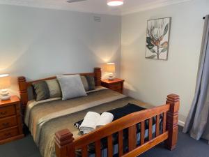 a bedroom with a bed with two night stands and two lamps at Easy Wagga Stopover, Spacious & Comfortable in Forest Hill