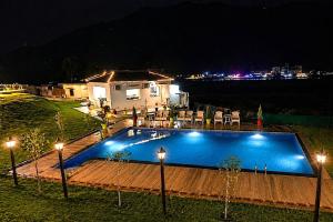a swimming pool at night with lights and a house at Aqua Tree Resort in Rishīkesh