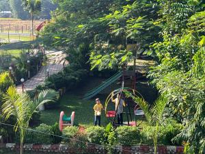 two children playing on a playground in a park at North Queen Resort in Mal bazar