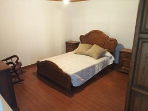 a bedroom with a wooden bed with two night stands at Casa Lameiro in Cedeira