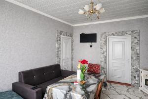 a living room with a couch and a table at Warm Welcome Ivanovka in İvanovka