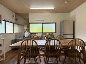 a kitchen with a large wooden table and chairs at 近露の家 -chikatsuyunoie- in Tanabe