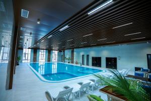 a large swimming pool in a building with chairs at Рамада Нукус in Nukus